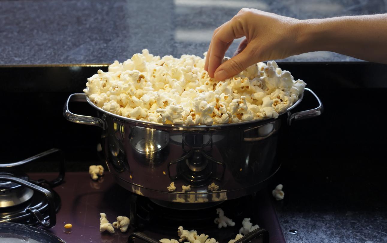 A stainless pan full of popcorn.