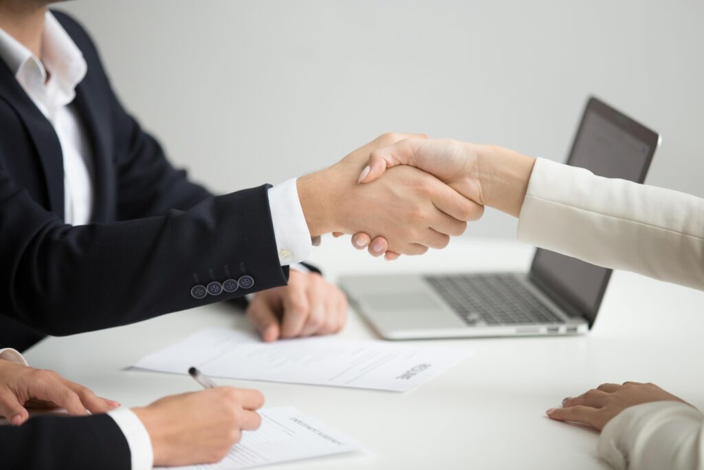 hr handshaking successful candidate getting hired new job closeup 1 1024x683